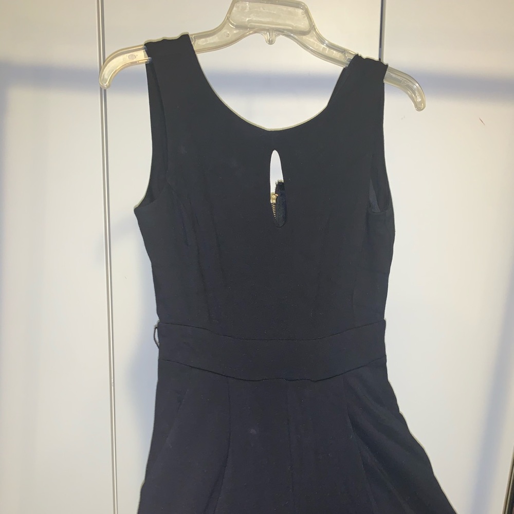 Black jumpsuit with gold zippers at the back legs